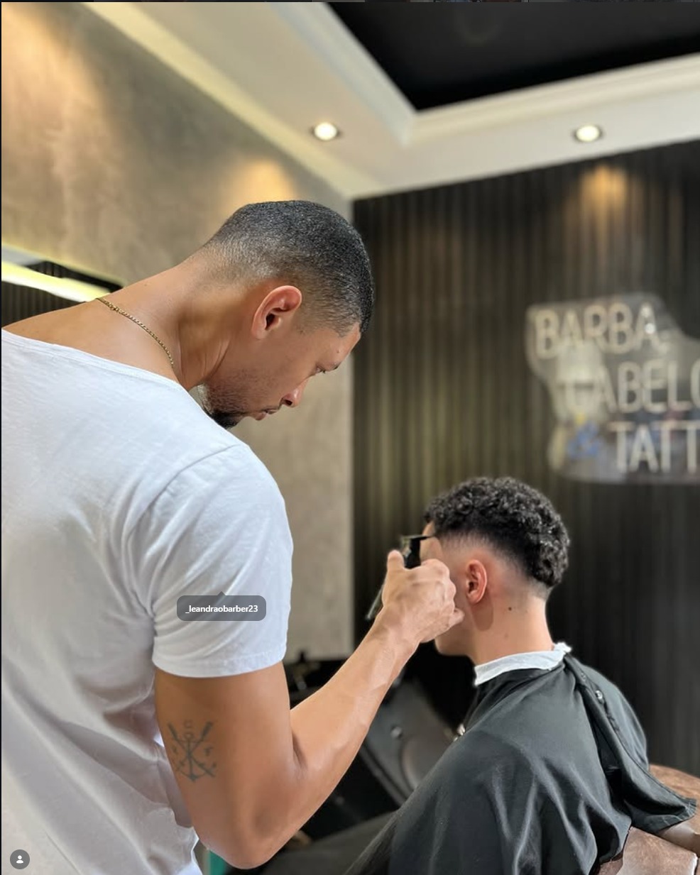 Barbeiro finalizando o corte de um cliente